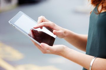 Close up of young woman using digital tablet.