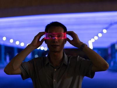 Someone using virtual reality glasses at night in a well lit location.