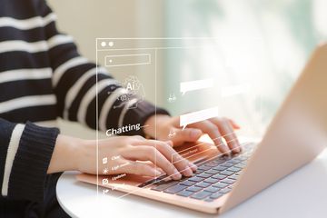 A young person using a chatbot on a laptop computer. 