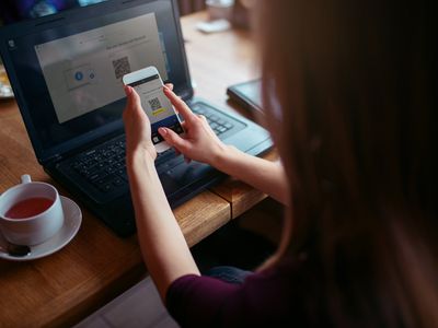 A woman connecting her iPhone to a Windows 11 PC using Phone Link.